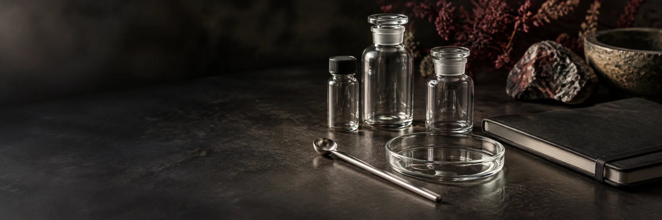 Unmarked laboratory glassware and a notebook on a research desk.